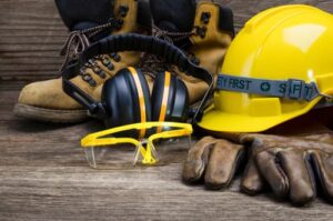 construction hat, glasses, boots and gloves on the ground