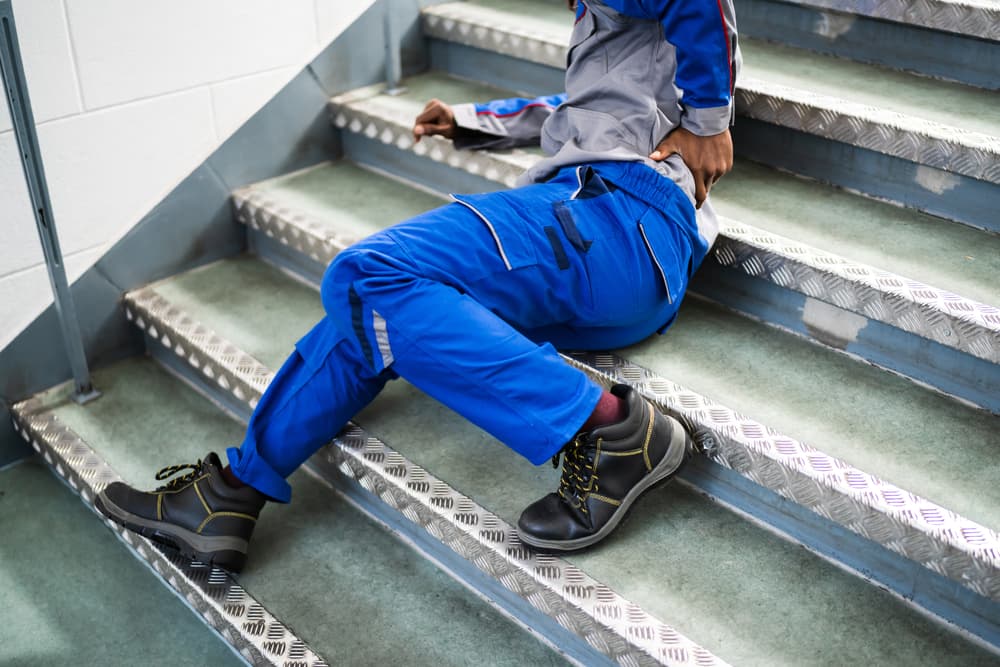 Worker lying on a staircase after slipping and falling.