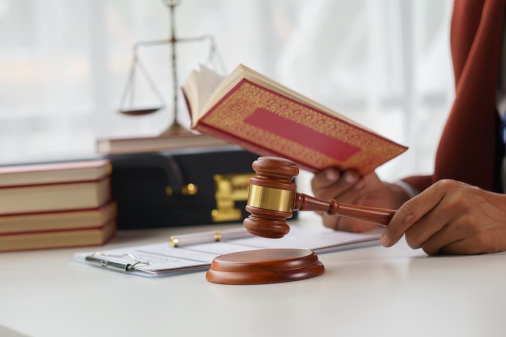 A lawyer or legal advisor discussing the statute of limitations with a colleague in a professional office setting. They are seated at a desk with legal documents and books spread out, emphasizing a formal environment. 