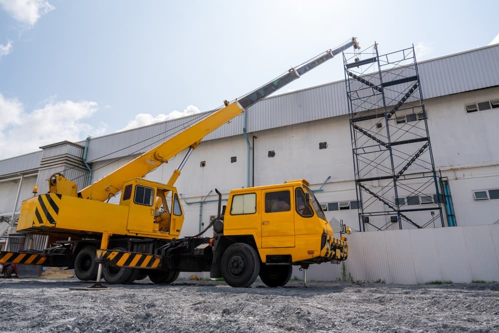 A mobile crane assisting with roof repair at a construction site.






