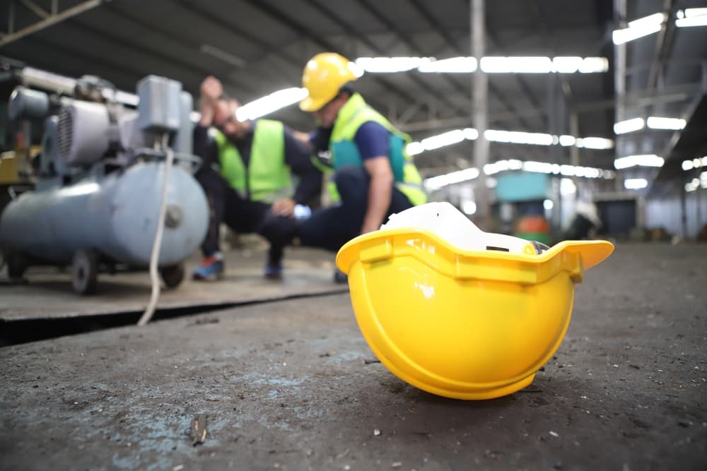 A construction worker is injured on-site, and the safety team assists the employee.







