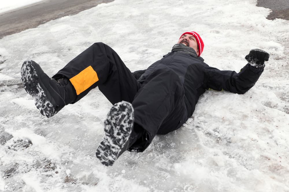 A man is lying on an icy path.