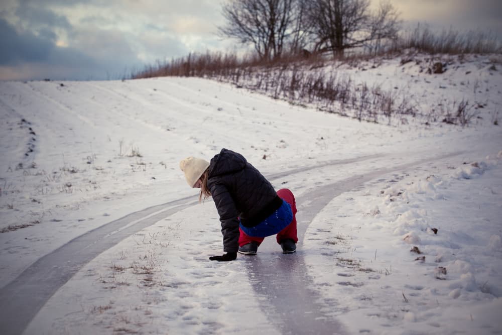 Slipping on icy and snowy road tracks in the countryside on a freezing winter day, highlighting the dangers of winter weather conditions.